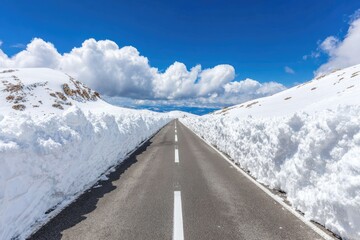 Snowy mountain road under a vibrant blue sky