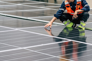 Worker inspects solar panels on rooftop installation during daytime maintenance
