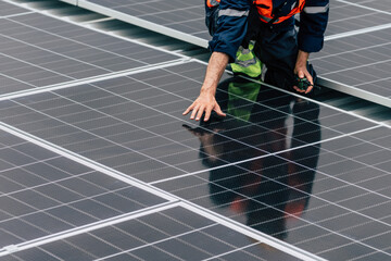 Technician performing maintenance on solar panels at a renewable energy facility in bright sunlight