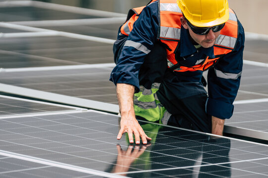 Technician working on solar panels during daytime installation at a commercial building rooftop - Powered by Adobe
