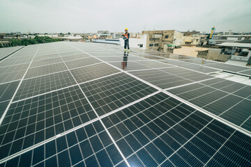 Technician installing solar panels on a rooftop in an urban area during overcast weather