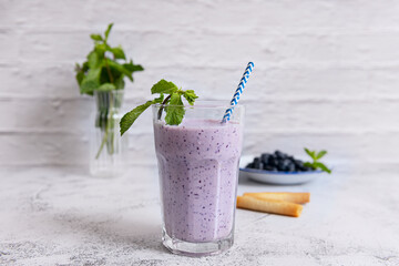 Creamy blueberry and banana smoothie with a touch of honey, garnished with fresh berries and mint...