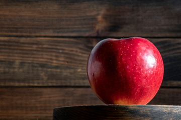 foto de una manzana roja con gotas de agua con fondo de madera oscura