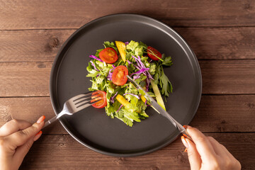 Person forking salad with a fork.A vibrant green salad, featuring fresh lettuce,