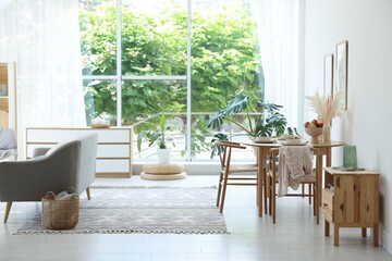 Stylish table setting, chairs, sofa and decor in dining room. Interior design