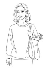 A young woman stands, holding a reusable bag filled with groceries, looking forward.