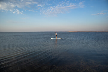Woman on sup board. A beautiful young woman relaxes on a SUP board. Standup paddleboarding