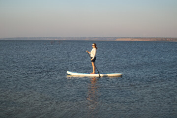Woman Relaxing on Stand Up Paddle Board in Calm Lake. Summer Water Sport, Outdoor Adventure,...