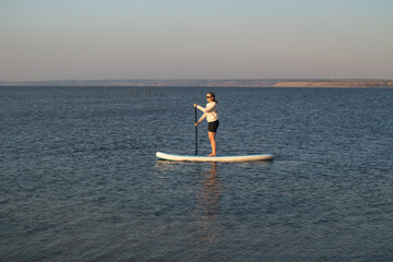 Woman on Stand Up Paddle Board in Calm Lake. Summer Water Sport, Outdoor Adventure, Peaceful Nature...
