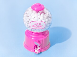 Pink candy dispenser on blue background