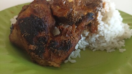 Plate with grilled chicken and white rice, perfect for food blogs, menu designs, and restaurant advertisements looking for delicious meal visuals.