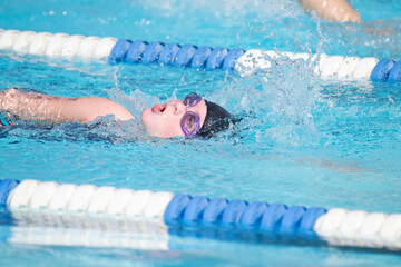 Young Girl Takes a Breath While Swimming Freestyle at a Swim Meet