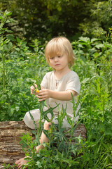 Little boy running barefoot through the green grass