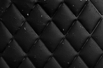 Scratched black leather material with rhombic geometric pattern. Damaged surface. Abstract dark textured background