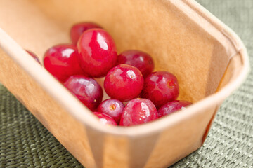 Red ripe grapes in recycled grocery cardboard packaging