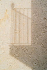 Shadow of balcony railing on textured wall