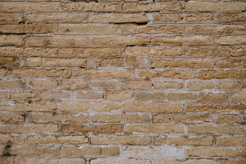 Close-up of tan weathered brick wall texture