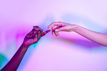 Multiethnic hands reaching out against colorful background