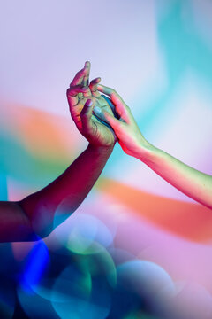 Multiethnic hands exchanging light and unity
