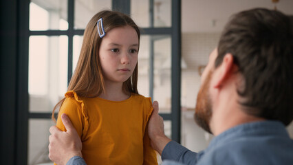 Caring Caucasian dad man guy male touching talk offended sad little child kid at home babysitter...