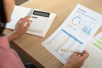 Work from home. Analyzing monthly budget with calculator and reports.