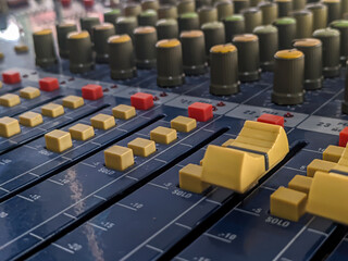 Close-up of audio mixer faders in recording studio, electronic equipment for sound systems.