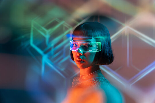 Latin woman exploring virtual reality with futuristic glasses - Powered by Adobe