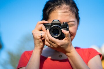 Asian woman capturing the perfect shot outdoors