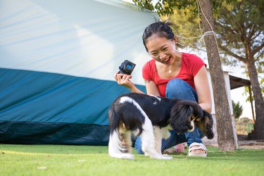 Young woman photographing her dog in the backyard