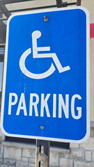 blue parking sign featuring a universal symbol for accessibility and the word PARKING. Highlights...