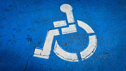 blue handicapped parking symbol painted on an asphalt surface, representing accessibility and inclusivity for people with disabilities. Rustic disabled parking sign