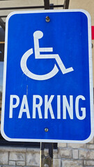 blue parking sign featuring a universal symbol for accessibility and the word PARKING. Highlights the availability of designated spaces for differently disabled individuals for convenience.