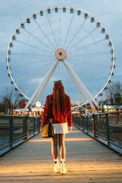 Back view of woman at ferris wheel during fall in montreal