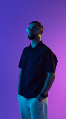 Man with glasses set against a neon-lit backdrop. Concept of relaxed digital work culture, tech...