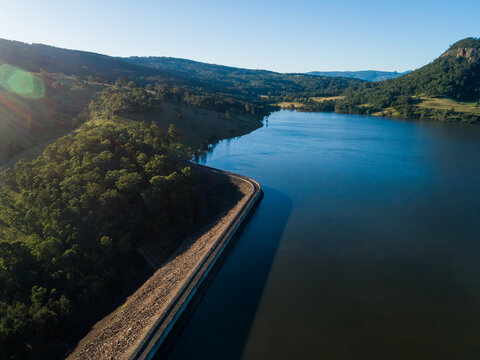 sunlight over Glennies creek dam wall water supply seen from aerial view in Hunter Valley
