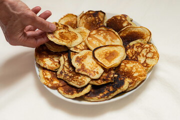 Hand reaching for a delicious golden pancake
