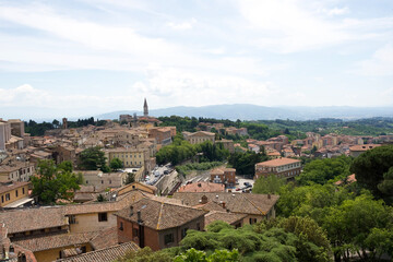 Obraz premium Scenic view of historic buildings and lush greenery in the beautiful town of Perugia, Italy with rolling hills in background