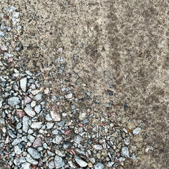 Natural background of compacted sand and crushed gravel with embedded rough stones