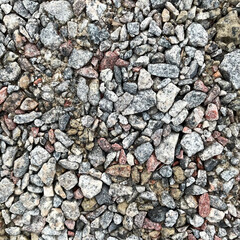 Top view of small crushed gravel stones with rough angular texture with natural mineral colors for...