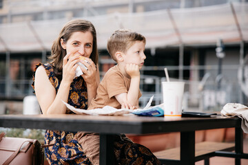 Mother and son enjoying a fast food meal outdoors in genoa, italy