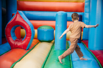Child running and playing inside colorful inflatable playground