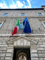 Flag of Italy fluttering in the wind over a square in Rome. Italian and European Union flags.