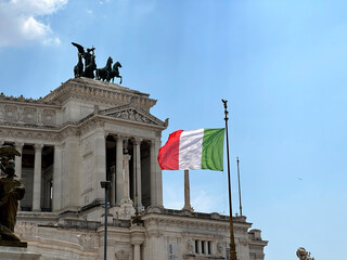 White stone historical monument to Vittorio Emanuele II in Rome on Venice Square, architectural monument of ancient Roman Empire, Italian flag waving on the sides of famous building. High quality 4k