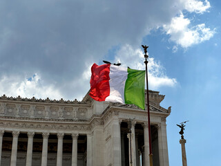 White stone historical monument to Vittorio Emanuele II in Rome on Venice Square, architectural monument of ancient Roman Empire, Italian flag waving on the sides of famous building. High quality 4k