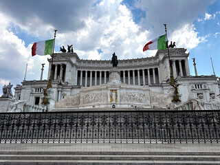 White stone historical monument to Vittorio Emanuele II in Rome on Venice Square, architectural monument of ancient Roman Empire, Italian flag waving on the sides of famous building. High quality 4k