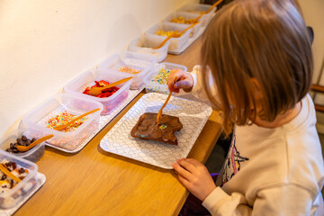 Little girl making chocolate candies at the Chocolate Museum in Prague. A hands-on experience showcasing traditional chocolate-making techniques