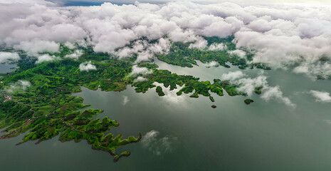 Aerial drone shot of lush green Indian landscape with winding lakes and rivers under dramatic...