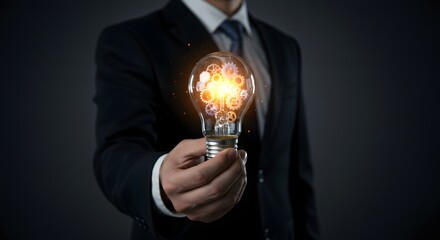 Business Idea and Innovation Concept: Businessman Holding Lightbulb with Gears