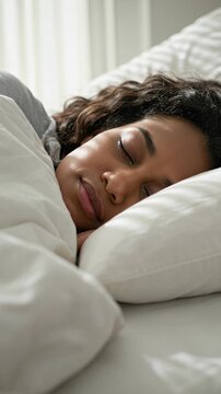A woman sleeping peacefully in a cozy bed, vertical footage