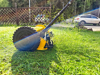 Lawn mower cutting grass in a well-maintained yard during bright daylight hours